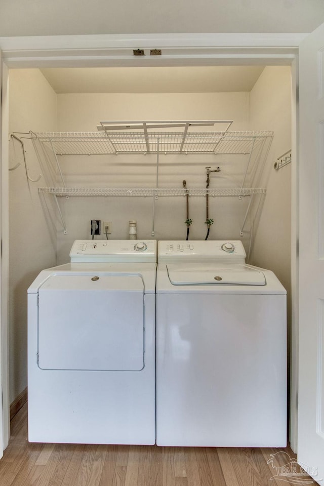 laundry area featuring laundry area, washing machine and dryer, and light wood-style floors