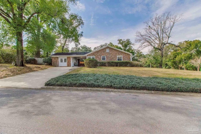 ranch-style home with concrete driveway, brick siding, a front yard, and fence