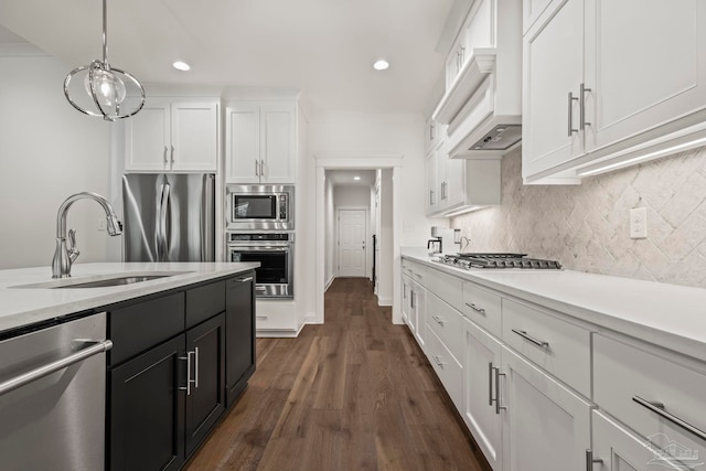 kitchen featuring sink, white cabinets, decorative light fixtures, appliances with stainless steel finishes, and dark hardwood / wood-style flooring