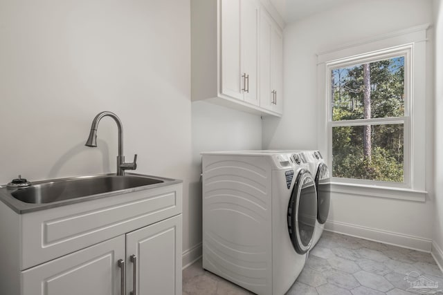 laundry area with sink, independent washer and dryer, light tile patterned floors, and cabinets