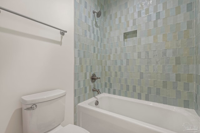 bathroom featuring tiled shower / bath and toilet