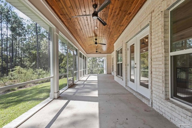 unfurnished sunroom with ceiling fan and wooden ceiling