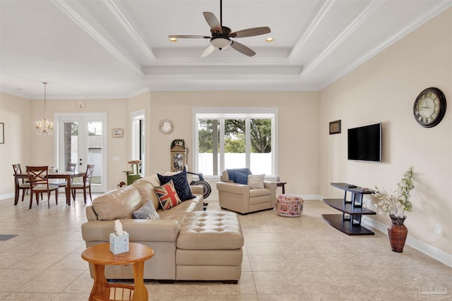 living room featuring french doors, a tray ceiling, light tile patterned floors, ceiling fan with notable chandelier, and ornamental molding