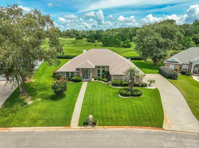 view of front of home featuring a front lawn, a chimney, and driveway