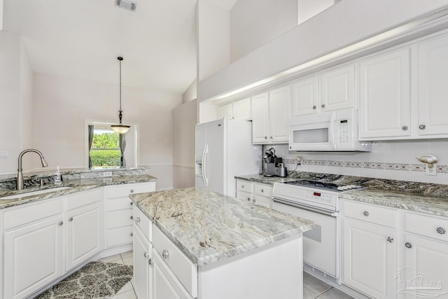 kitchen featuring white appliances, light tile patterned flooring, a sink, backsplash, and a center island