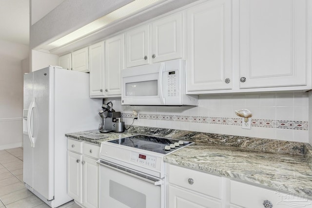 kitchen featuring backsplash, light stone countertops, light tile patterned floors, white cabinets, and white appliances