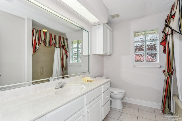 full bathroom with tile patterned floors, toilet, a textured ceiling, baseboards, and vanity