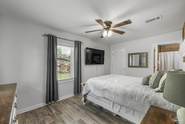 bedroom with a ceiling fan, baseboards, visible vents, and dark wood-style flooring