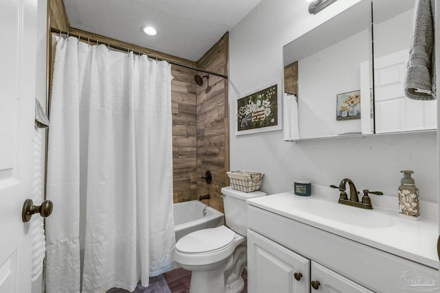 bathroom featuring a textured ceiling, shower / bath combo, vanity, and toilet