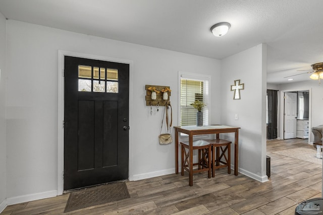 foyer entrance featuring baseboards and wood finished floors
