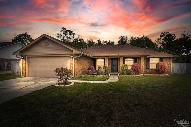 ranch-style house with an attached garage, brick siding, concrete driveway, and a yard