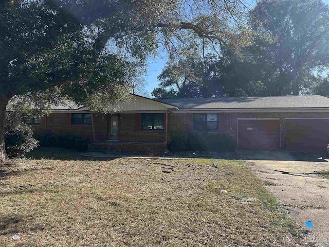 single story home with a garage, driveway, and brick siding