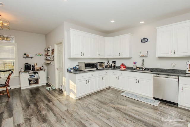 kitchen with hardwood / wood-style flooring, sink, white cabinets, and appliances with stainless steel finishes