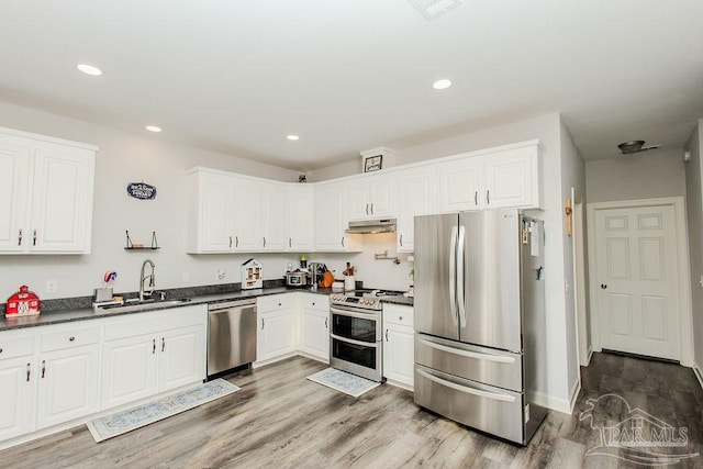 kitchen featuring wood-type flooring, sink, white cabinets, and appliances with stainless steel finishes