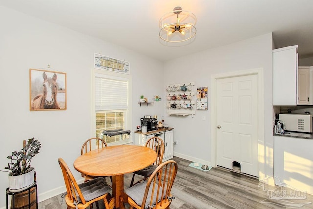 dining area with light hardwood / wood-style flooring and an inviting chandelier