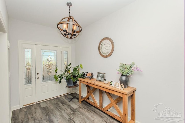 foyer entrance with wood-type flooring and a chandelier