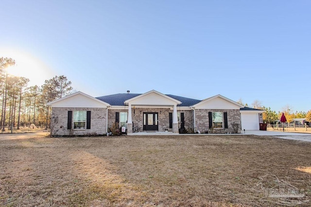 ranch-style house featuring a garage and a front lawn