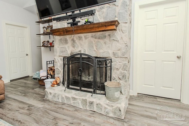 room details with hardwood / wood-style floors and a stone fireplace