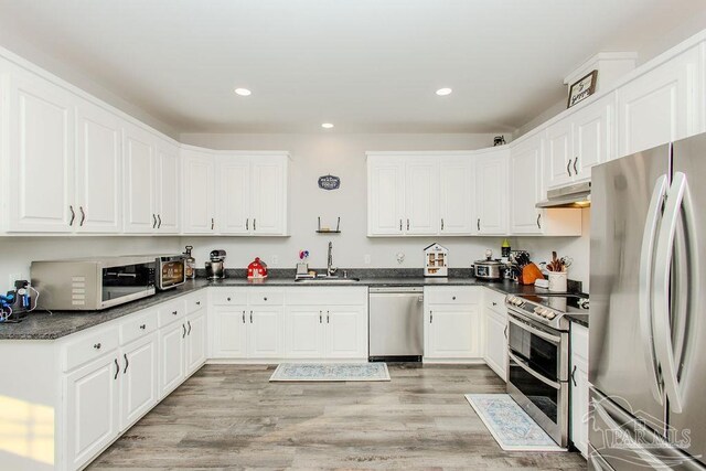 kitchen featuring stainless steel appliances, white cabinetry, and sink