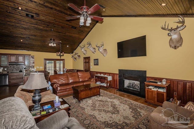 living area with a wainscoted wall, dark wood-type flooring, a multi sided fireplace, and wood ceiling