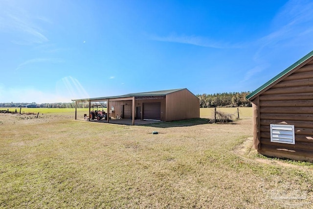 exterior space with an outbuilding, a rural view, and a detached garage