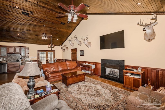 living room featuring wooden ceiling, a wainscoted wall, ceiling fan, wood finished floors, and a fireplace