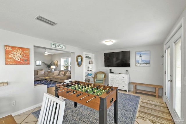 rec room with ceiling fan, built in features, and light tile patterned floors