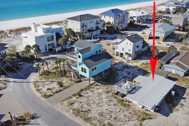 drone / aerial view featuring a water view and a view of the beach