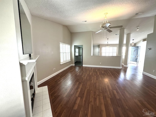 152 Mirabelle Cir, Pensacola, FL 32514 - unfurnished living room featuring a ceiling fan, wood finished floors, a tiled fireplace, baseboards, and vaulted ceiling