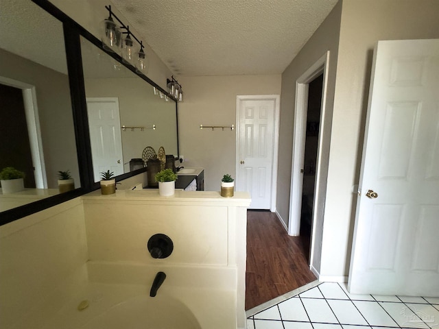 full bathroom featuring tile patterned flooring and a textured ceiling