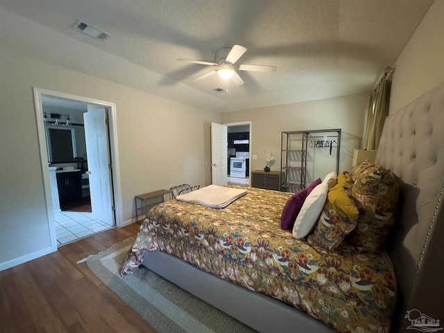 bedroom with a textured ceiling, wood finished floors, and visible vents