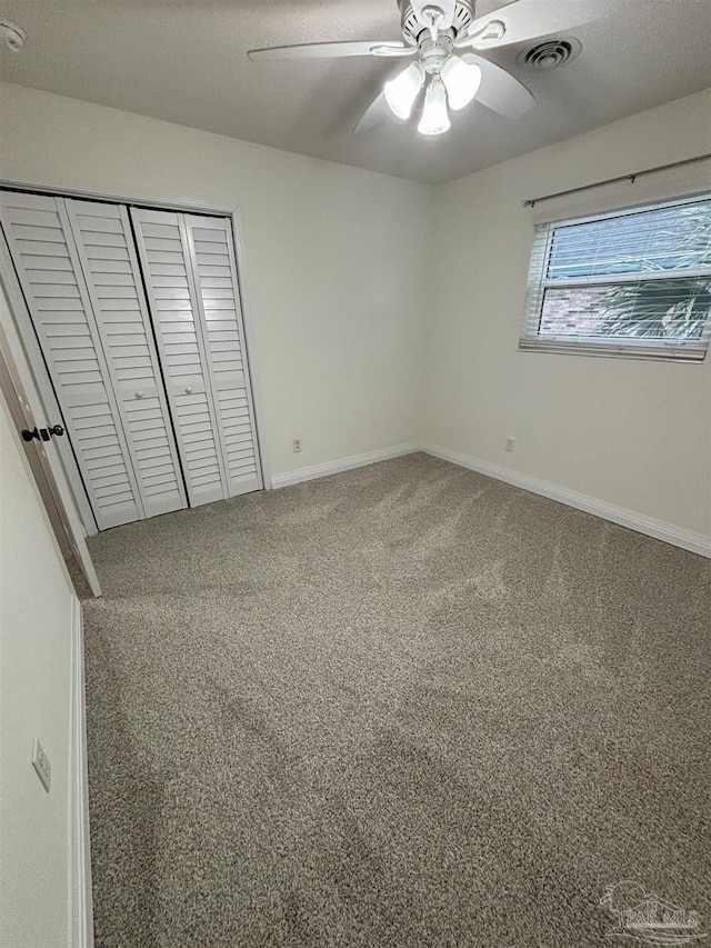 unfurnished bedroom with carpet floors, ceiling fan, and a closet