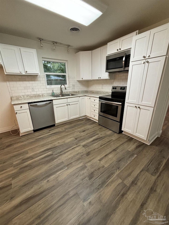 kitchen with stainless steel appliances, sink, white cabinets, and dark hardwood / wood-style floors