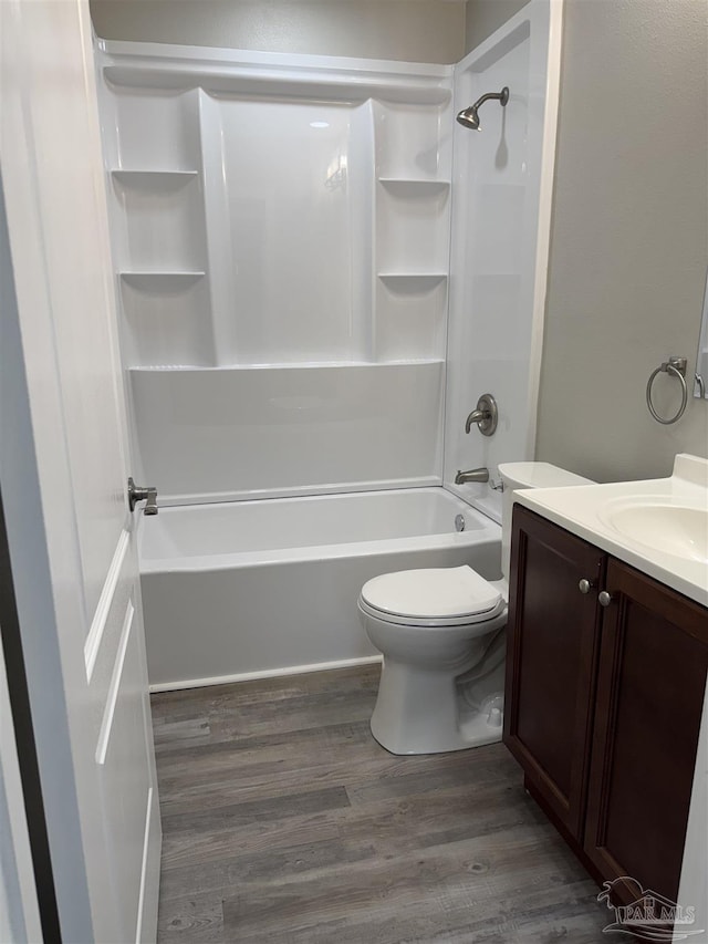 full bathroom with vanity, wood-type flooring, toilet, and washtub / shower combination