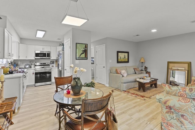 living area with light wood-style flooring and baseboards