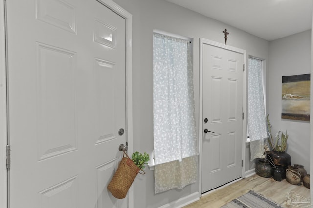 entryway featuring baseboards and light wood finished floors