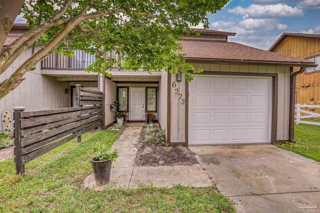 view of front of home with a balcony, driveway, an attached garage, fence, and roof with shingles