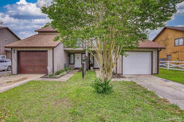 view of front of house with fence, a shingled roof, a front lawn, driveway, and a garage