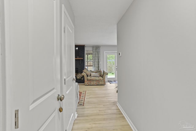 hallway featuring baseboards and light wood-style floors