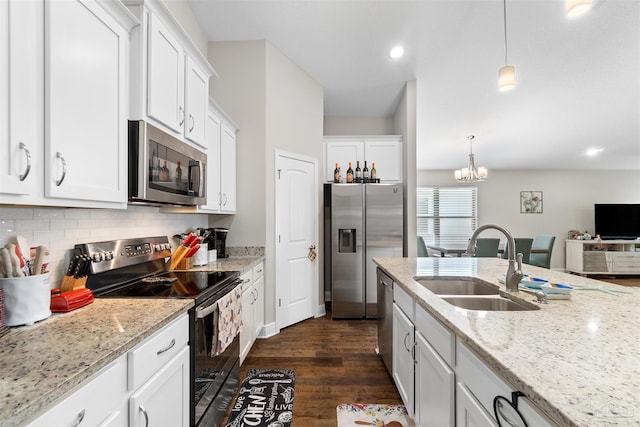 kitchen with pendant lighting, stainless steel appliances, sink, and white cabinets