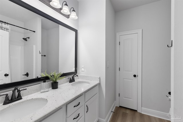 9938 Suwanee Ln, Pensacola, FL 32526 - full bathroom with wood finished floors, double vanity, a shower, and baseboards
