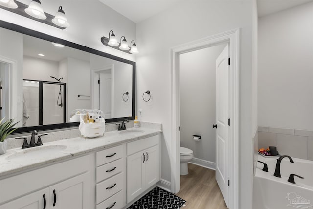 9938 Suwanee Ln, Pensacola, FL 32526 - full bathroom featuring a garden tub, a shower stall, double vanity, toilet, and wood finished floors