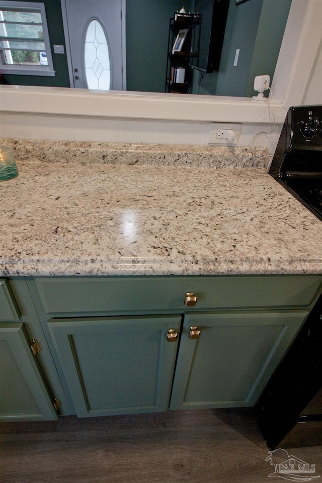 interior details with green cabinetry, dark hardwood / wood-style flooring, and electric range