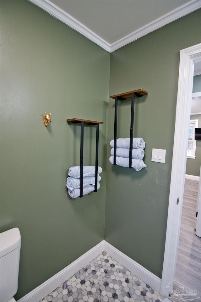 bathroom featuring crown molding and toilet