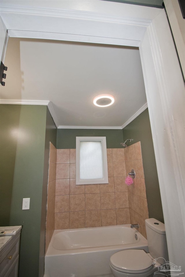 full bathroom featuring crown molding, vanity, toilet, and tiled shower / bath combo