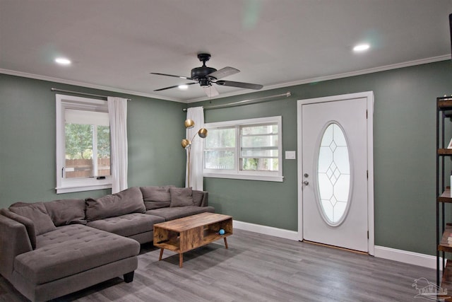 living room with crown molding, a wealth of natural light, and light wood-type flooring