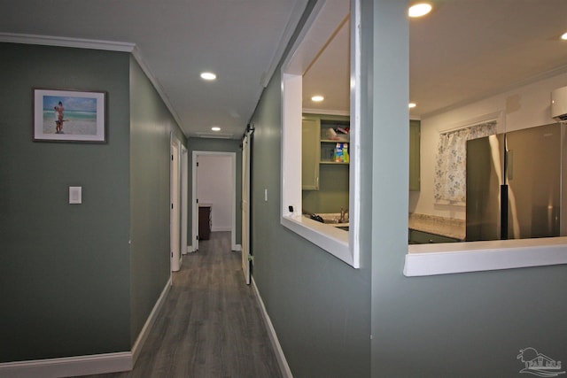 corridor with wood-type flooring, a barn door, and crown molding