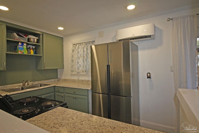 kitchen with sink, black electric range, an AC wall unit, green cabinets, and light stone countertops