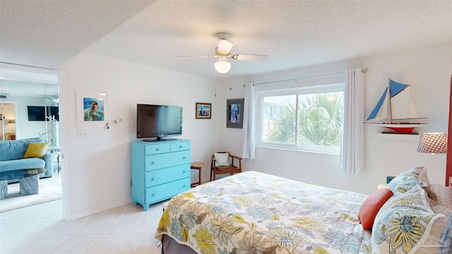bedroom featuring light tile patterned floors, baseboards, ceiling fan, and a textured ceiling