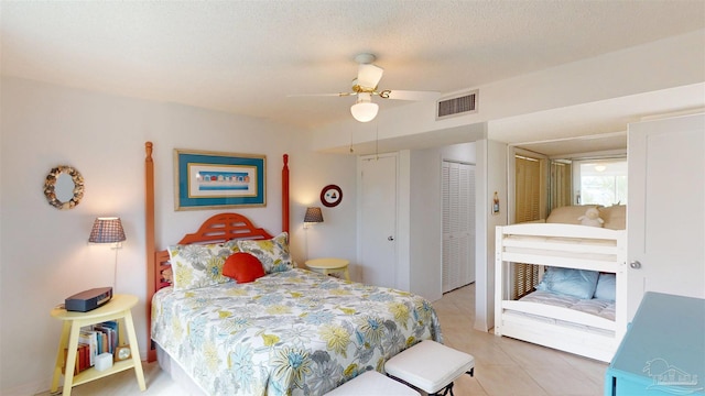 bedroom featuring a textured ceiling, visible vents, ceiling fan, and light tile patterned floors